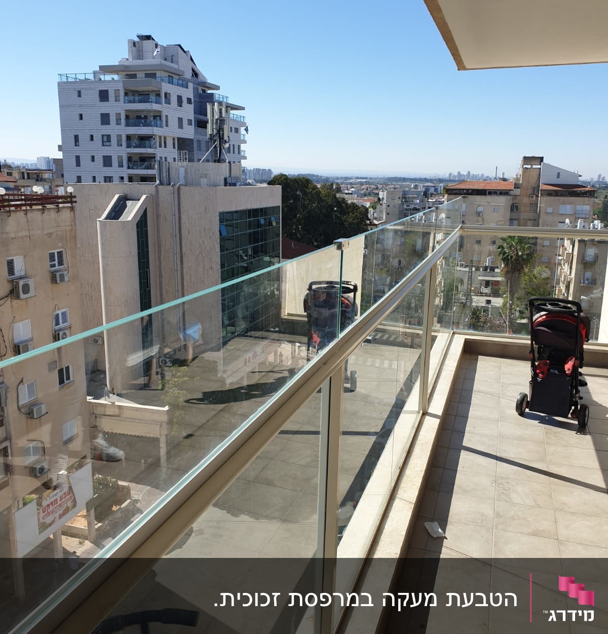 מעקה זכוכית במרפסת עם נוף עירוני